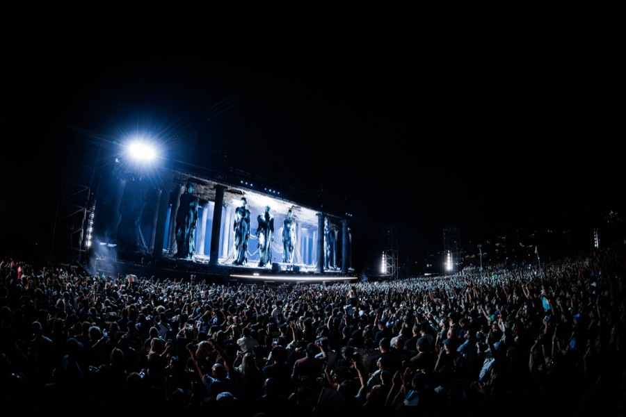 The ÆDEN stage lit blue at night above thousands of raised hands