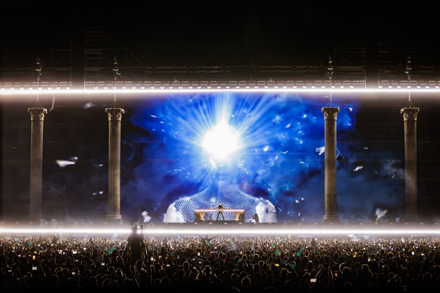 A burst of blue and white light from the ÆDEN stage during the headline set